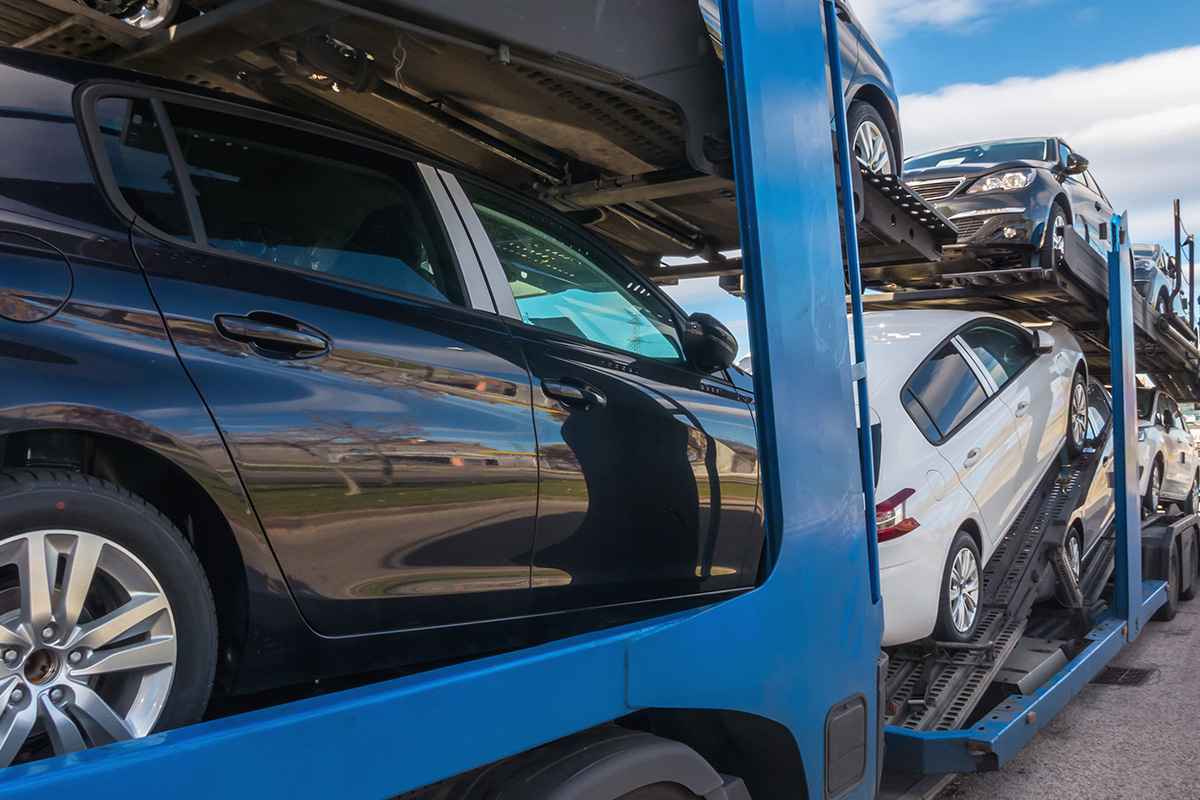 Zu sehen sind mehrere Autos, die auf einem Autotransporter verladen sind.